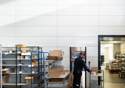电子中心仓库工人将包裹存储到自动化仓库Agilon -一个独特的解决方案，实现由客户控制的补货过程。